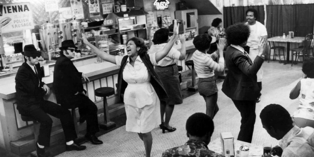 Aretha Franklin singing in a diner in The Blues Brothers. Image via City Journal